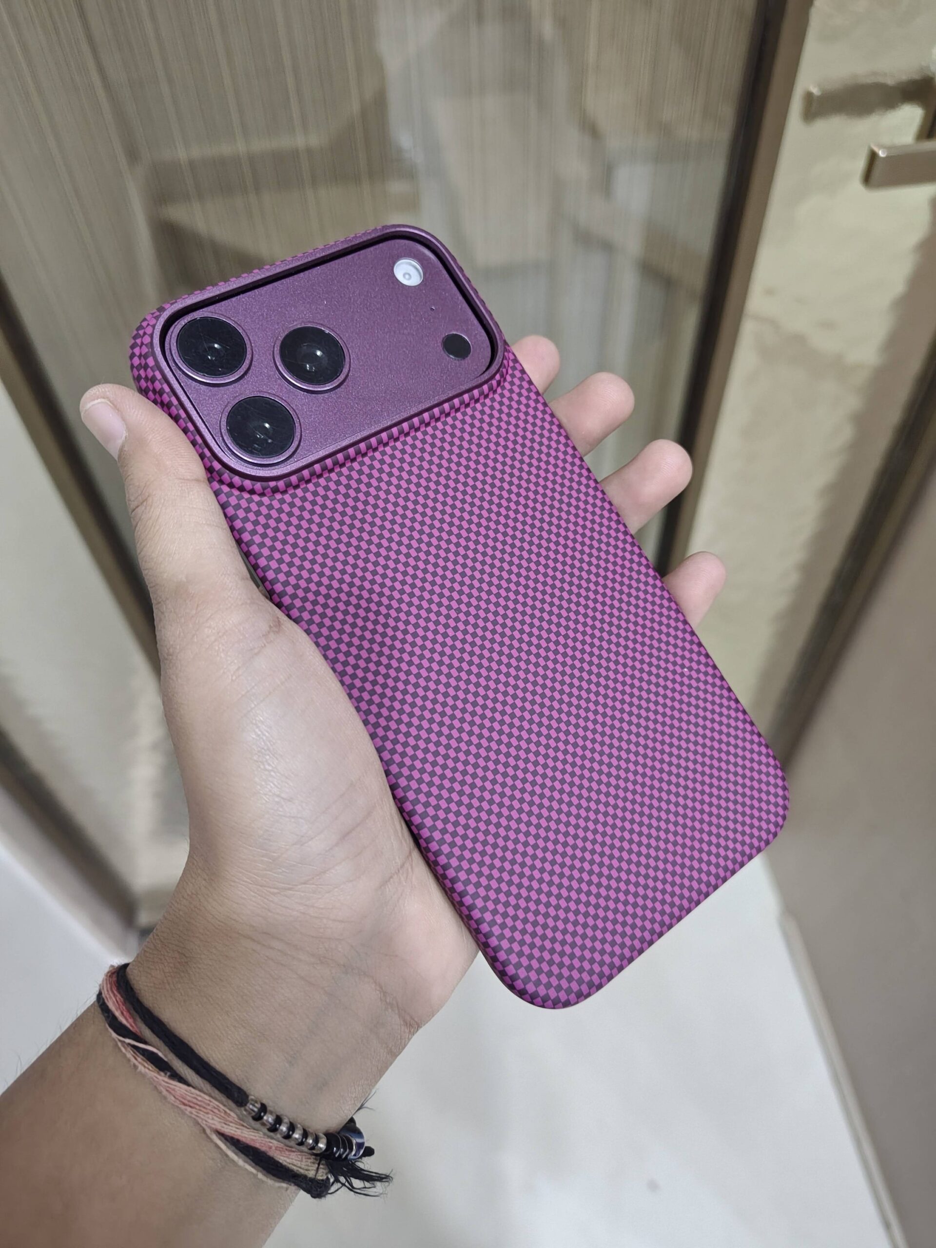 2026/09/2684-scaled.jpg dbrand Grip Case paired with a textured magenta/purple carbon fiber checkerboard skin - Image 1